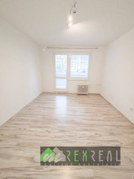 Helles Zimmer mit Holzdekorboden in einer 3-Zimmer-Wohnung.