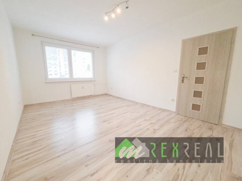 Ein Zimmer in einer 3-Zimmer-Wohnung mit einem Boden in Holzoptik und einem Fenster.