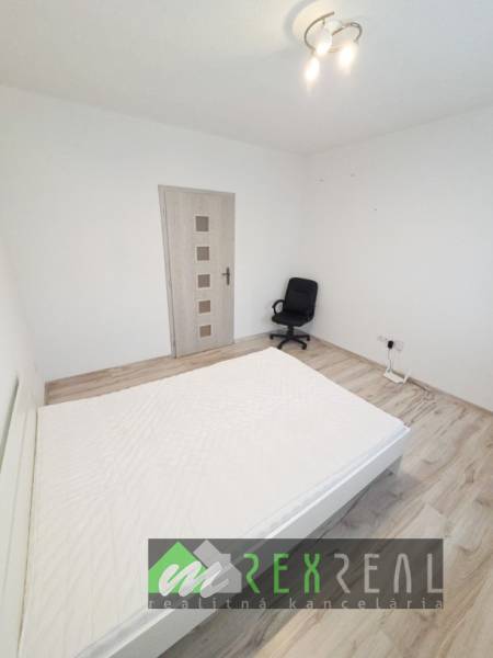 Helles Schlafzimmer in einer 3-Zimmer-Wohnung mit Holzboden und Bürostuhl.