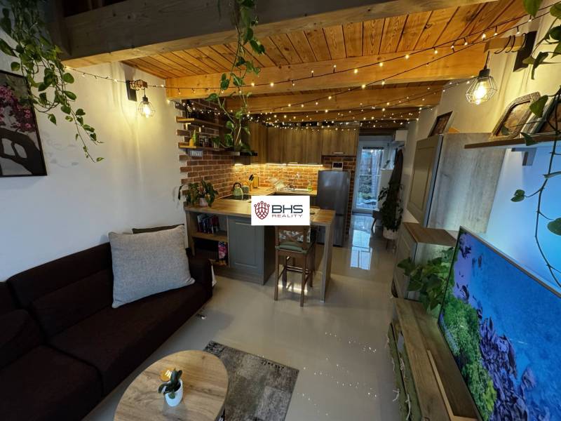 Wohnzimmer mit Ziegelverkleidung, Küchenzeile und Holzboden. Lager und Hallen.