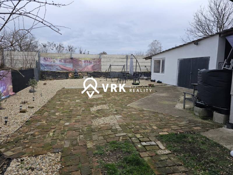 Der Hof des Einfamilienhauses in Hernádkak mit Pflastersteinen und einer Außensitzgelegenheit auf dem Grundstück.