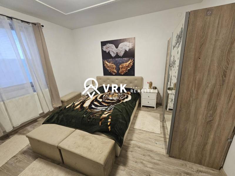 Schlafzimmer mit Bett, Schrank und Holzboden in einem Einfamilienhaus.