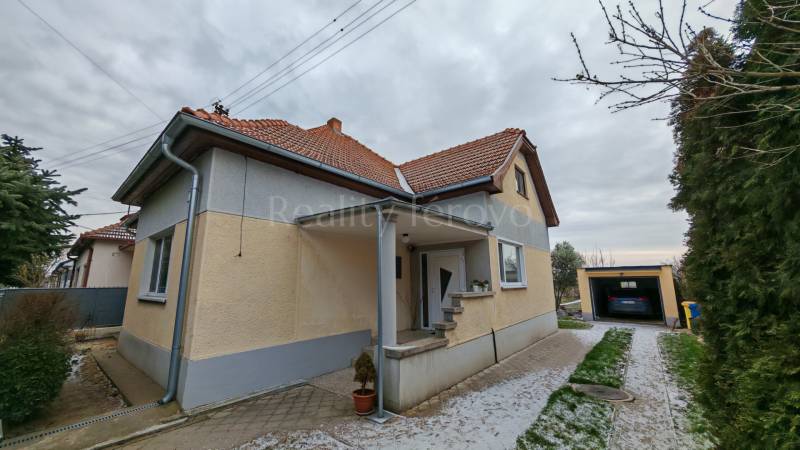 Ein Einfamilienhaus in Trnovec nad Váhom mit gepflegtem Garten und Garage in einer ruhigen Straße.