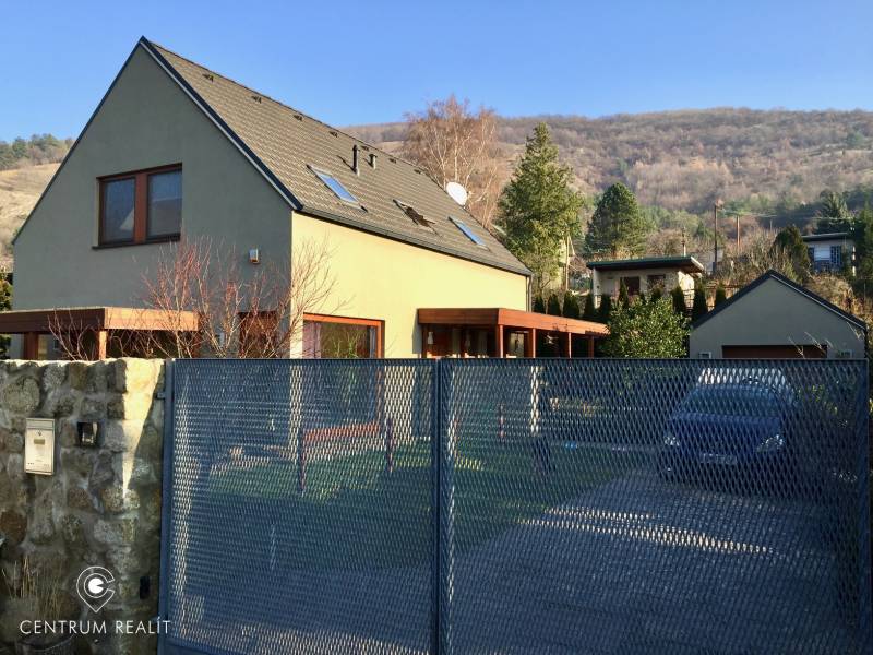 Ein Einfamilienhaus in der Kremeľská-Straße in Bratislava - Devín, umgeben von einem Garten und Bergen.