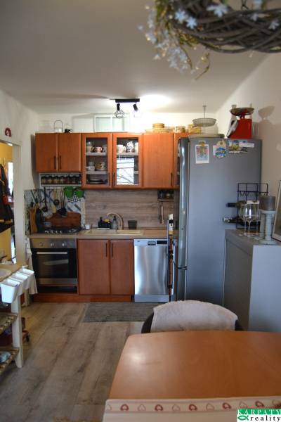 Küche in einer 3-Zimmer-Wohnung mit Holzboden und Geräten.