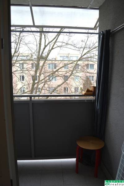 Balkon einer 3-Zimmer-Wohnung mit Blick auf die umliegende Architektur und einen Baum im Hintergrund.