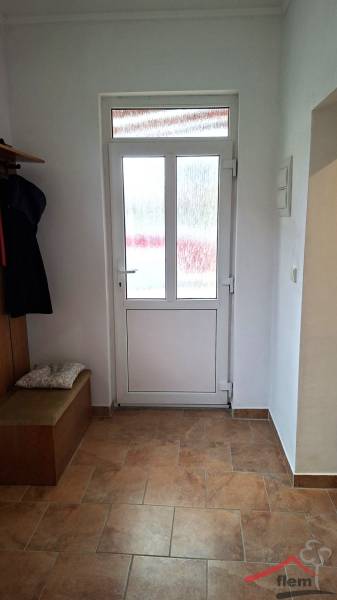 Innenraum eines Einfamilienhauses mit Glastüren und einem Boden in Holzoptik.