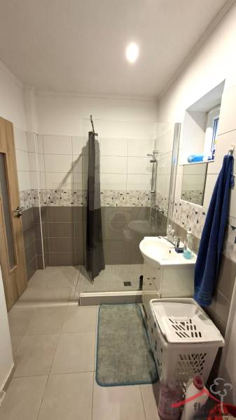 Badezimmer in einem Einfamilienhaus mit offener Dusche und Keramikfliesen.