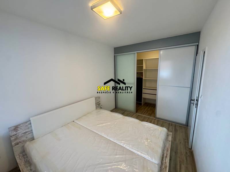 Schlafzimmer mit Doppelbett, Einbauschrank und Holzboden in einer 2-Zimmer-Wohnung.