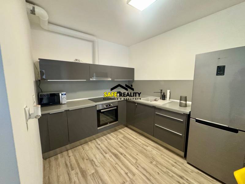 Küche in einer 2-Zimmer-Wohnung mit Holzboden und grauer Küchenzeile.