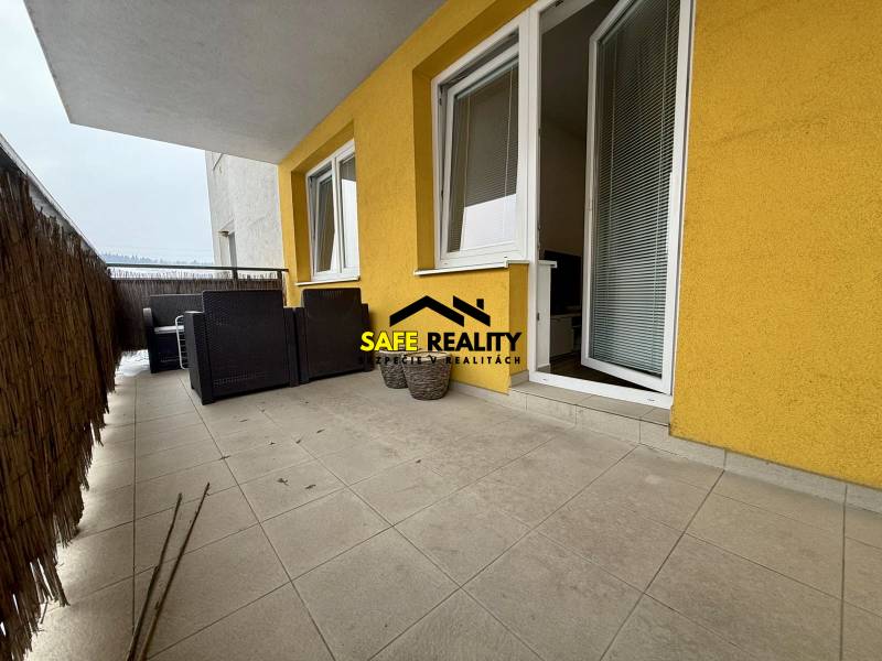 Balkon einer 2-Zimmer-Wohnung in Žilina mit gefliestem Boden und Gartenmöbeln.