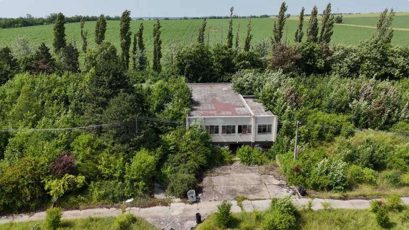 Ein Gebäude umgeben von Vegetation, geeignet für Gewerbegrundstücke in Ivanka pri Nitre.