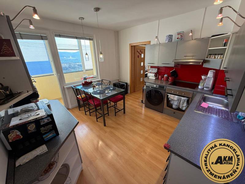 Küche in einer 3-Zimmer-Wohnung mit Holzboden und roten Akzenten.