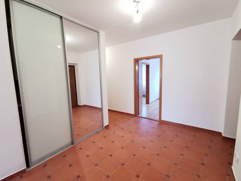 Flur in einer 4-Zimmer-Wohnung mit Fliesen und einem Einbauschrank mit Schiebetüren.