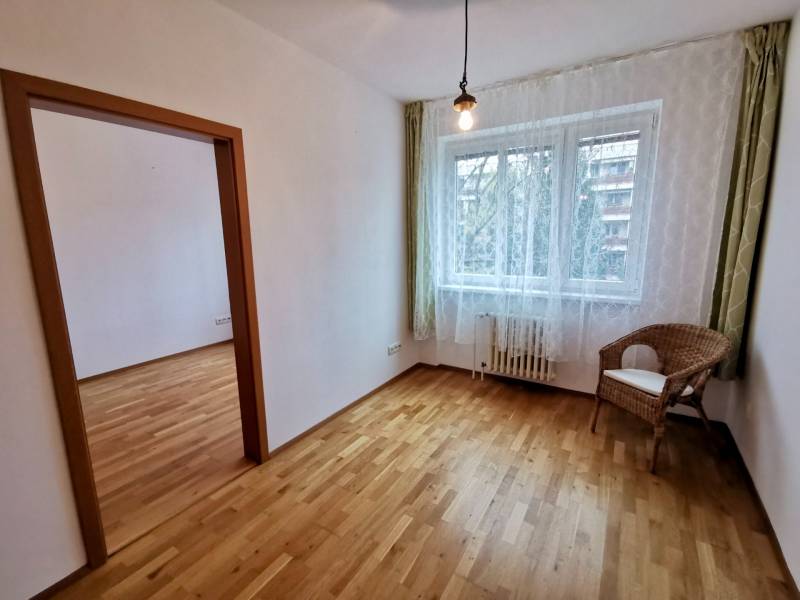 Ein Zimmer mit einem Stuhl und einem Boden in Holzoptik in einer 4-Zimmer-Wohnung.