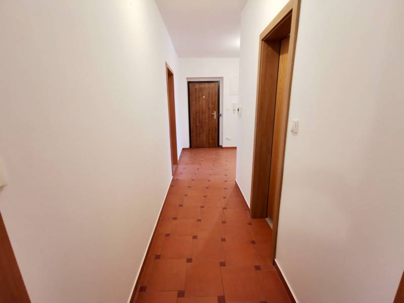 Flur mit hellen Wänden und Fliesen in einer 4-Zimmer-Wohnung.