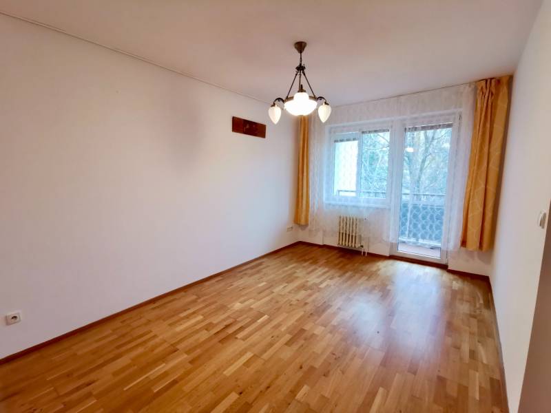 Geräumiges Zimmer mit hellem Interieur, Vorhänge, Boden mit Holzdekor, Leuchte.