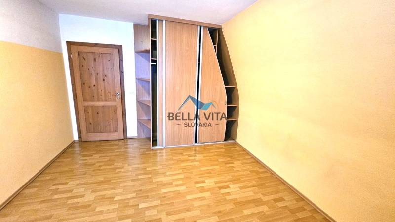 Ein Zimmer mit einem Holzboden, einem Einbauschrank und Holztüren.