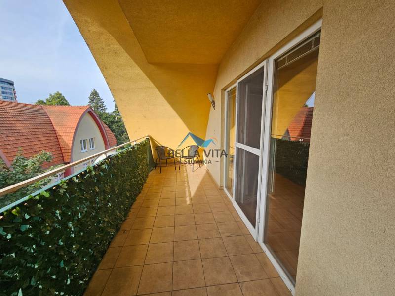 Ein Balkon mit Fliesen in einem Gebäude am Námestie detí in Galanta mit Blick auf die Dächer.