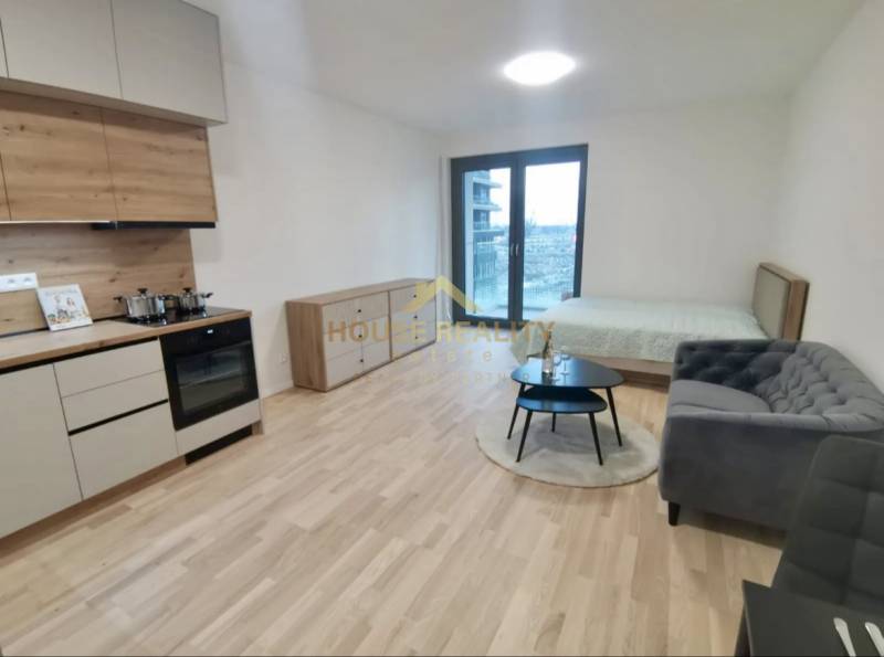 Küchenzeile, Bett, Sofa und Boden mit Holzdekor in einer Einzimmerwohnung.