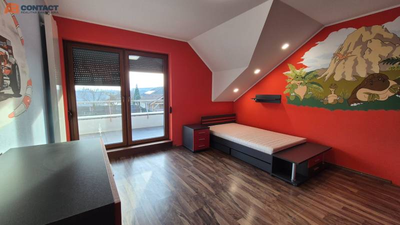 Kinderzimmer mit einer Wand mit Dinosauriermotiven und einem Boden in Holzoptik in einem Einfamilienhaus.