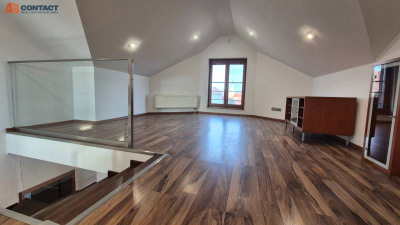 Dachbodenraum mit Holzboden, Treppe und großem Fenster.