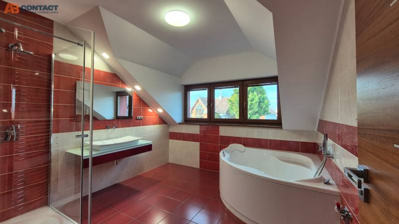 Badezimmer mit Eckbadewanne und Duschkabine in einem Einfamilienhaus.