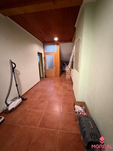 Der Flur in einem Einfamilienhaus mit Fliesen, einer Holzdecke und einem Stauraum.