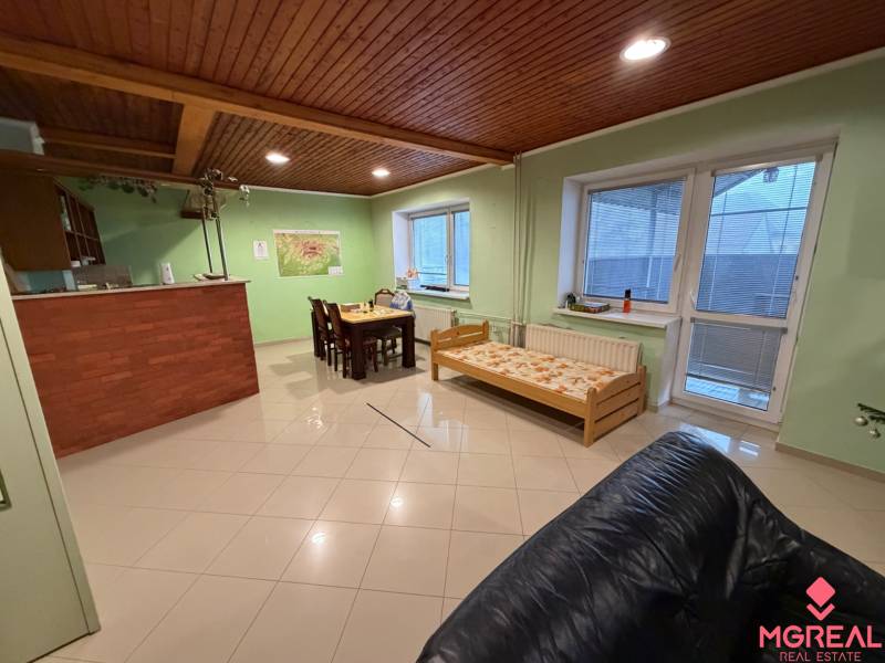 Wohnbereich mit Esstisch, Holzbalkendecke und Bett im Einfamilienhaus.