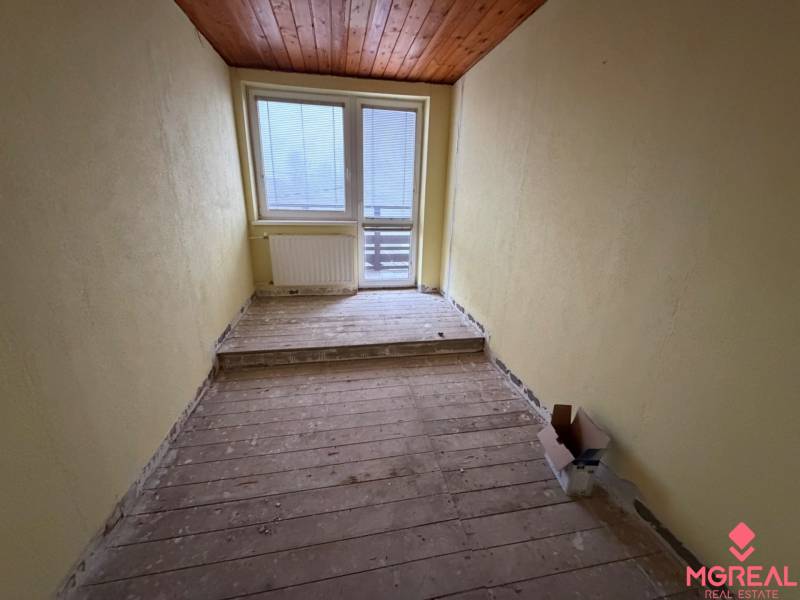 Gemütliches Zimmer mit Holzelementen und großem Fenster in einem Einfamilienhaus.