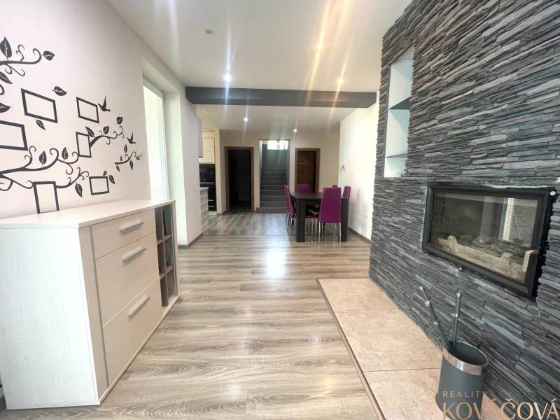 Innenraum eines Einfamilienhauses mit Kamin, Holzboden und Wanddekoration.