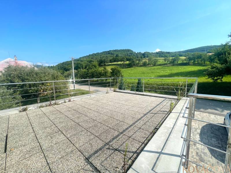 Die Terrasse des Einfamilienhauses in Melčice-Lieskové mit Blick auf die umliegende grüne Landschaft.