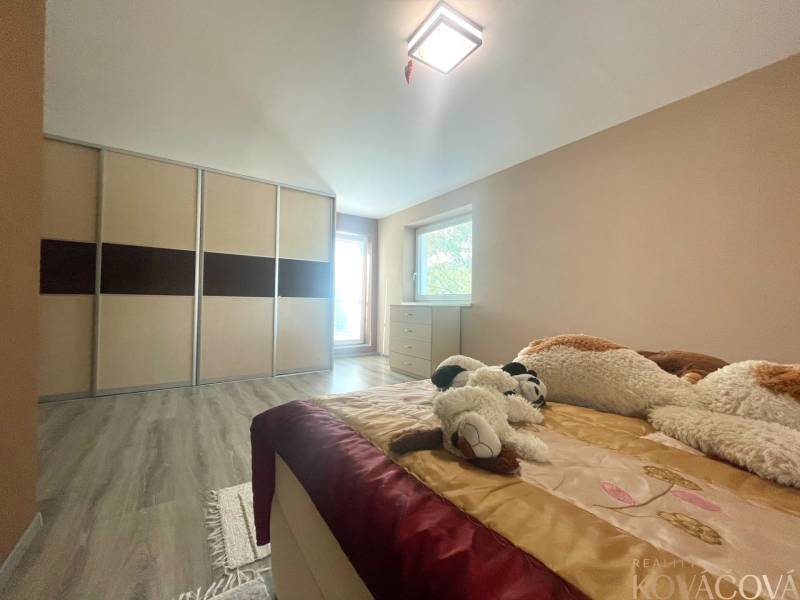 Schlafzimmer in einem Einfamilienhaus mit Holzboden, Einbauschrank und Plüschtieren.