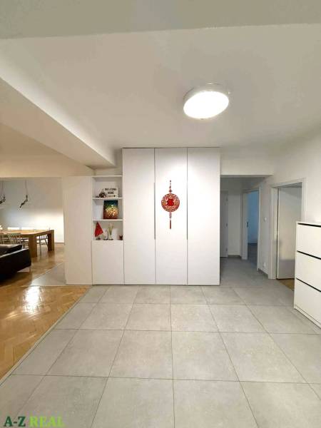 Flur in einer 4-Zimmer-Wohnung mit weißen Einbauschränken und Keramikfliesen.