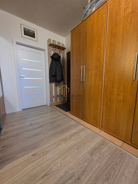 Innenraum einer 3-Zimmer-Wohnung mit Holzboden, Kleiderschrank und Garderobe.