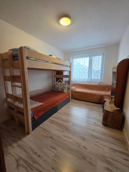 Kinderzimmer in einer 3-Zimmer-Wohnung mit Licht und Etagenbett, Boden mit Holzdekor.