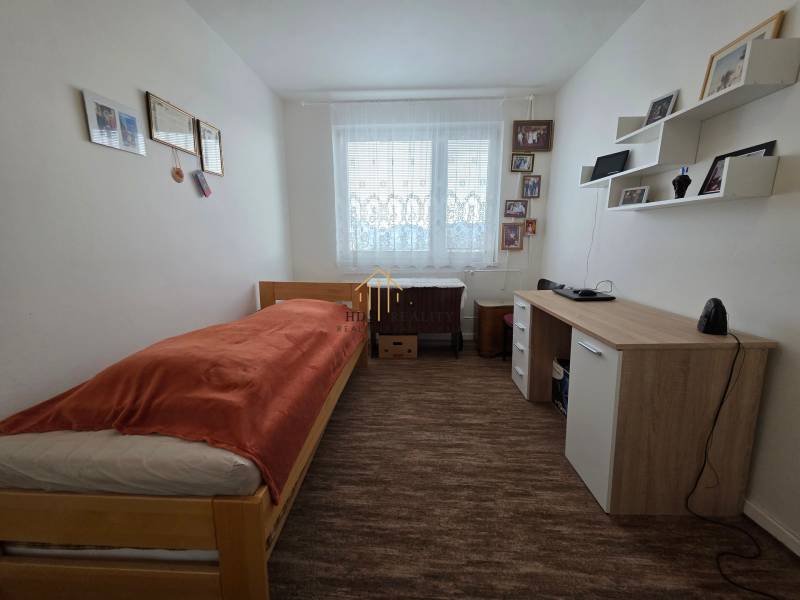 Einfach eingerichtetes Schlafzimmer oder Arbeitszimmer in einer 3-Zimmer-Wohnung mit Bett und Schreibtisch.
