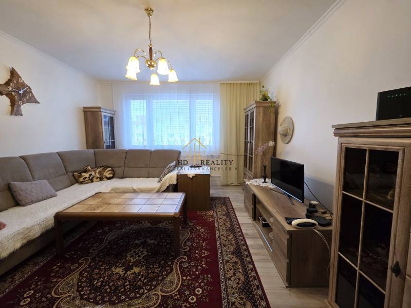 Wohnzimmer in einer 3-Zimmer-Wohnung mit Ecksofa und Holzboden.