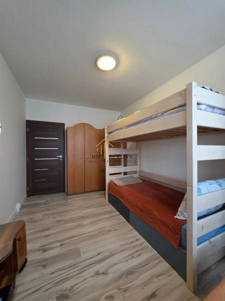 Kinderzimmer mit Etagenbett und Boden in Holzoptik in einer 3-Zimmer-Wohnung.