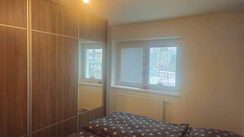 Schlafzimmer im Einfamilienhaus mit großem Schrank und Bett mit sternförmiger Bettwäsche.