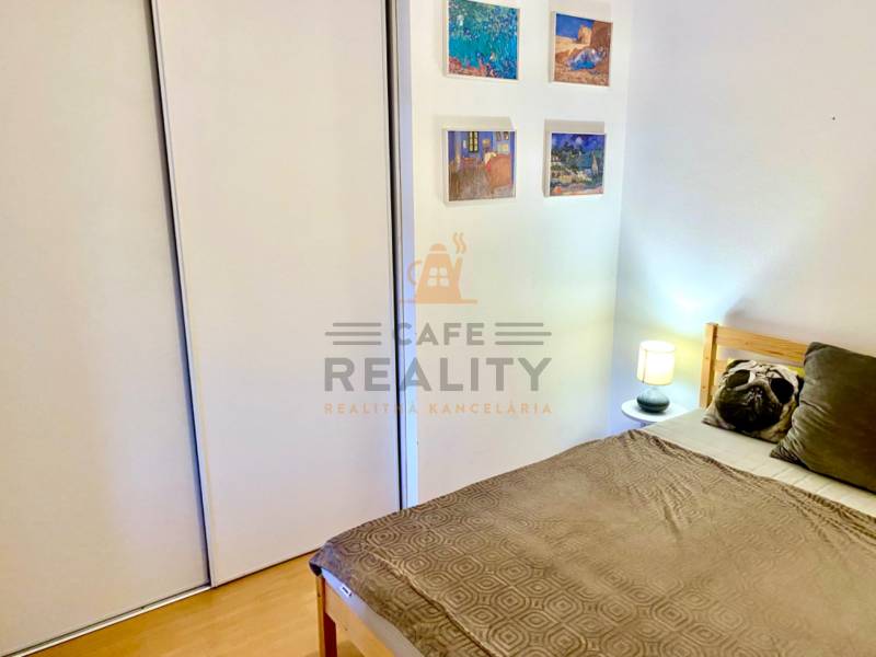 Schlafzimmer in einer 2-Zimmer-Wohnung mit Bett, Einbauschrank und Wanddekorationen.