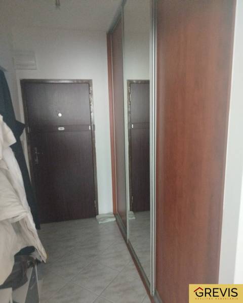 Flur mit Fliesen und einem großen Spiegel in einem Studio.