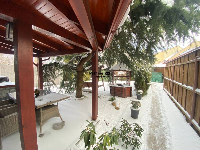 Eine verschneite Terrasse bei einem Einfamilienhaus in der Rampová-Straße in Košice mit einem Pavillon und Grünflächen.