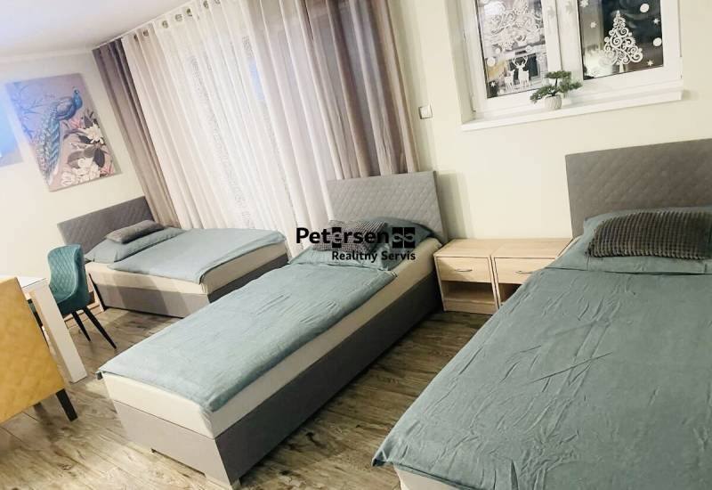 Drei Betten, zwei Nachttische und ein Boden mit Holzdekor in einem Einfamilienhaus.