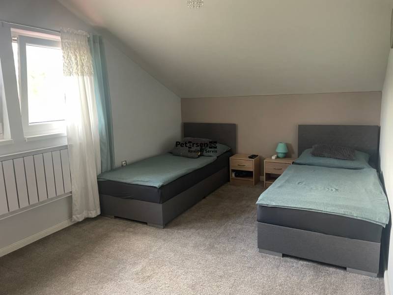 Doppelzimmer in einem Einfamilienhaus mit Teppichboden und Dachfenster.