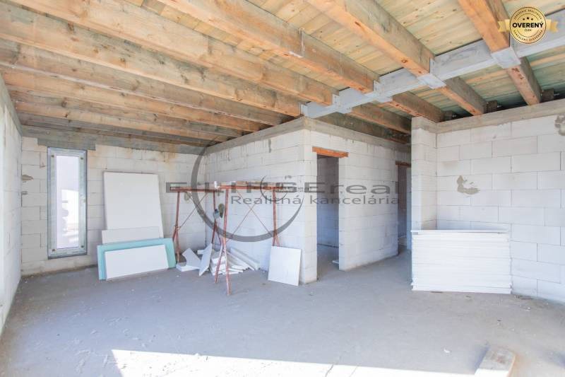 Ein Gebäude im Bau mit einer Holzdecke und Baumaterialien im Inneren.