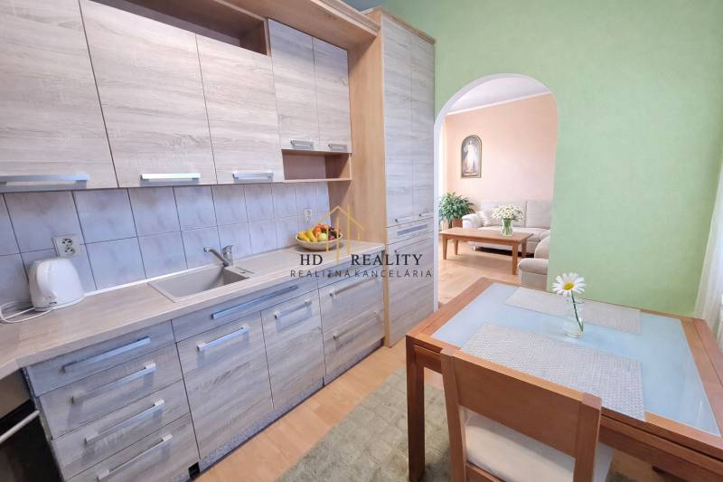 Küchenzeile mit Holzboden und Esstisch in einer 2-Zimmer-Wohnung.