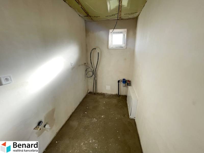 Ein leerer Raum mit einem Fenster in einem Einfamilienhaus, sichtbare Installationen und Vorbereitung für die Einrichtung.