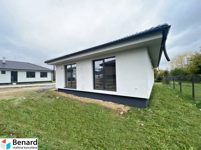 Ein Einfamilienhaus in Prešov mit Garten und großen Fenstern, das mit geräumigen und hellen Innenräumen ausgestattet ist.