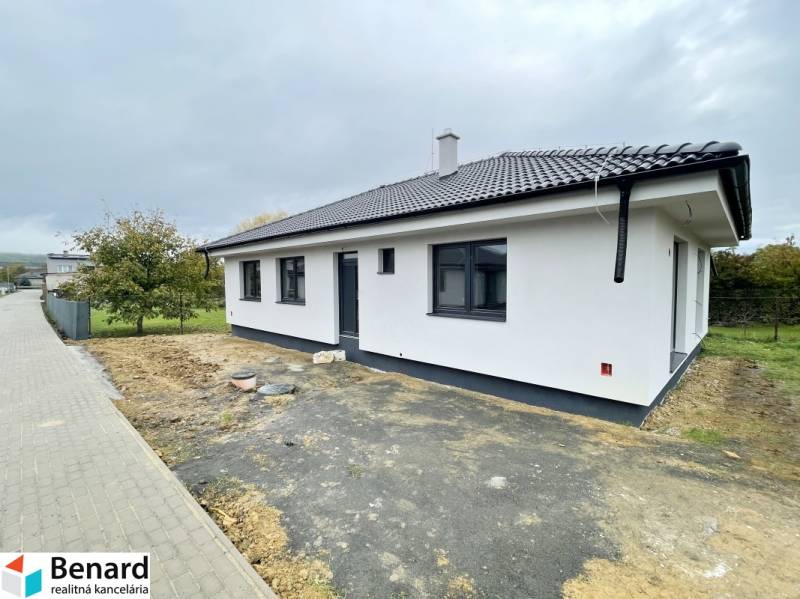 Ein Einfamilienhaus in Sol mit weißer Fassade und schrägem Dach, umgeben von einem Garten.